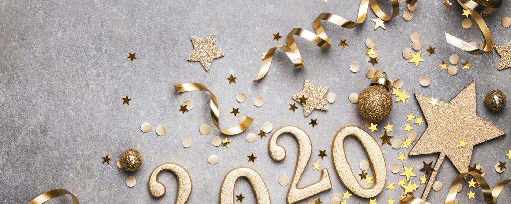 Holiday background with golden Christmas decorations and New year 2020 numbers and confetti stars top view with copy space.